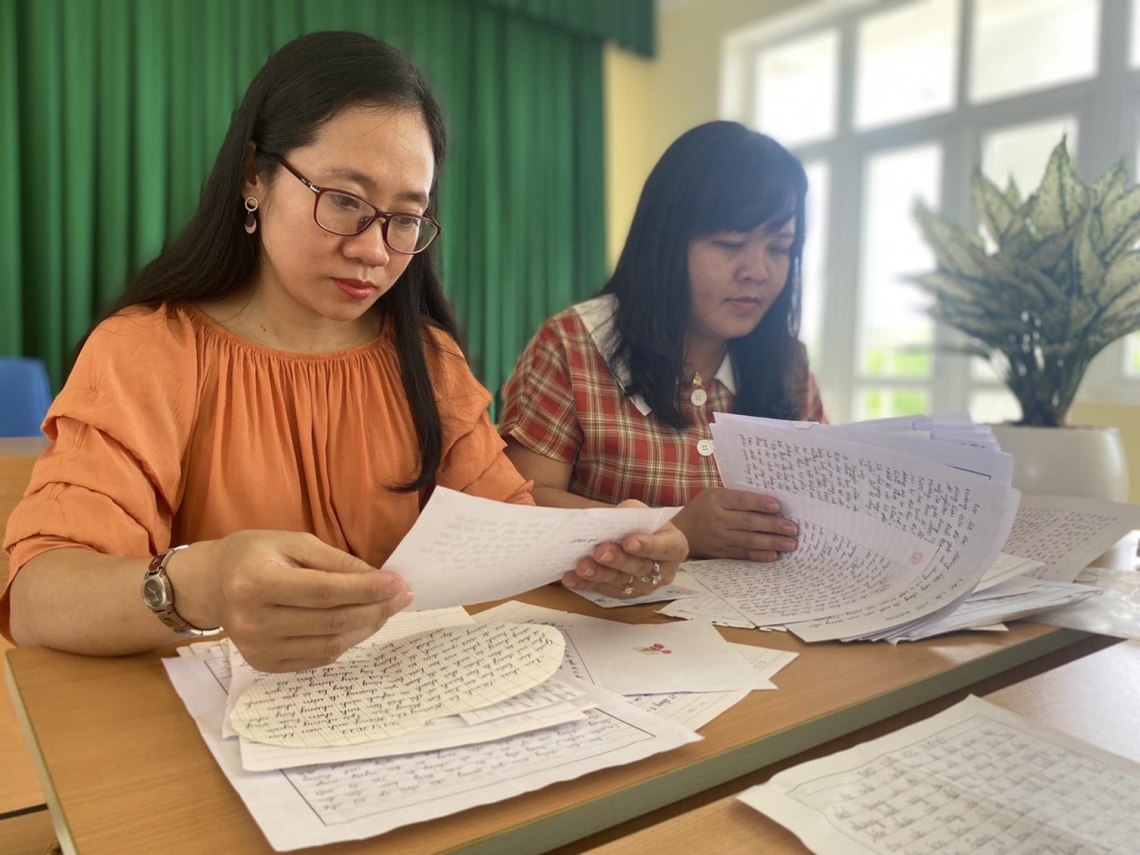 Hoai Thu (left) reads letters from students. Photo: UN Women/Thao Hoang